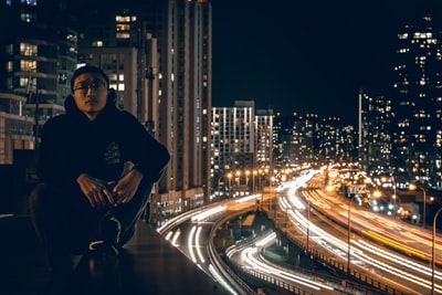 在timelapse照片中，一名男子在夜间坐在屋顶上